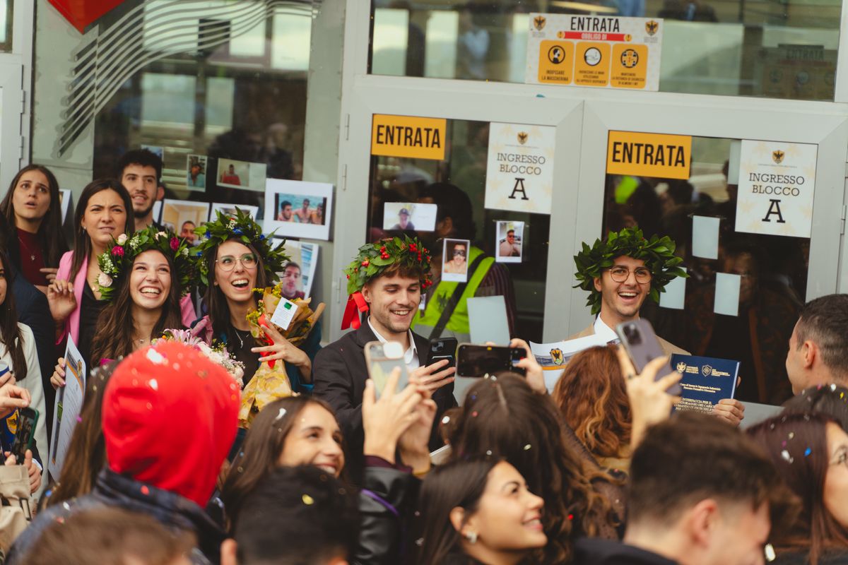 Neolaureati con la corona d'alloro festeggiati da amici e coriandoli