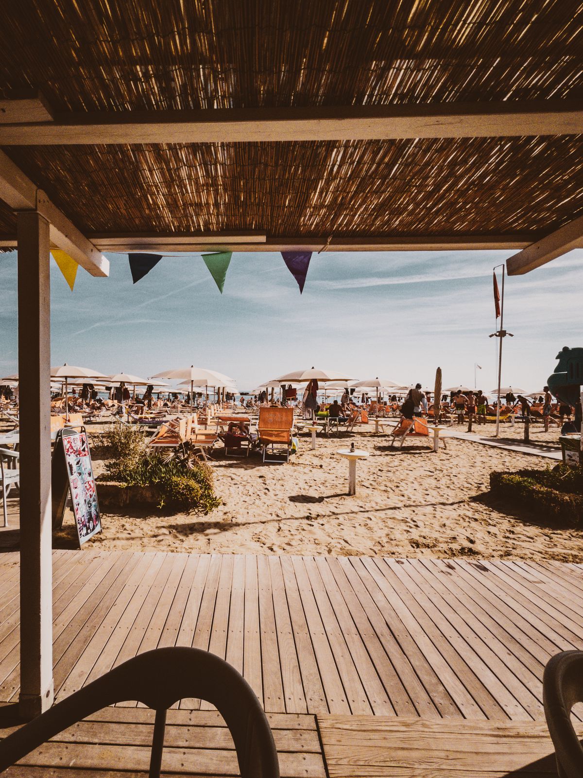 Ombrelloni e bandierine sulla spiaggia davanti al bar