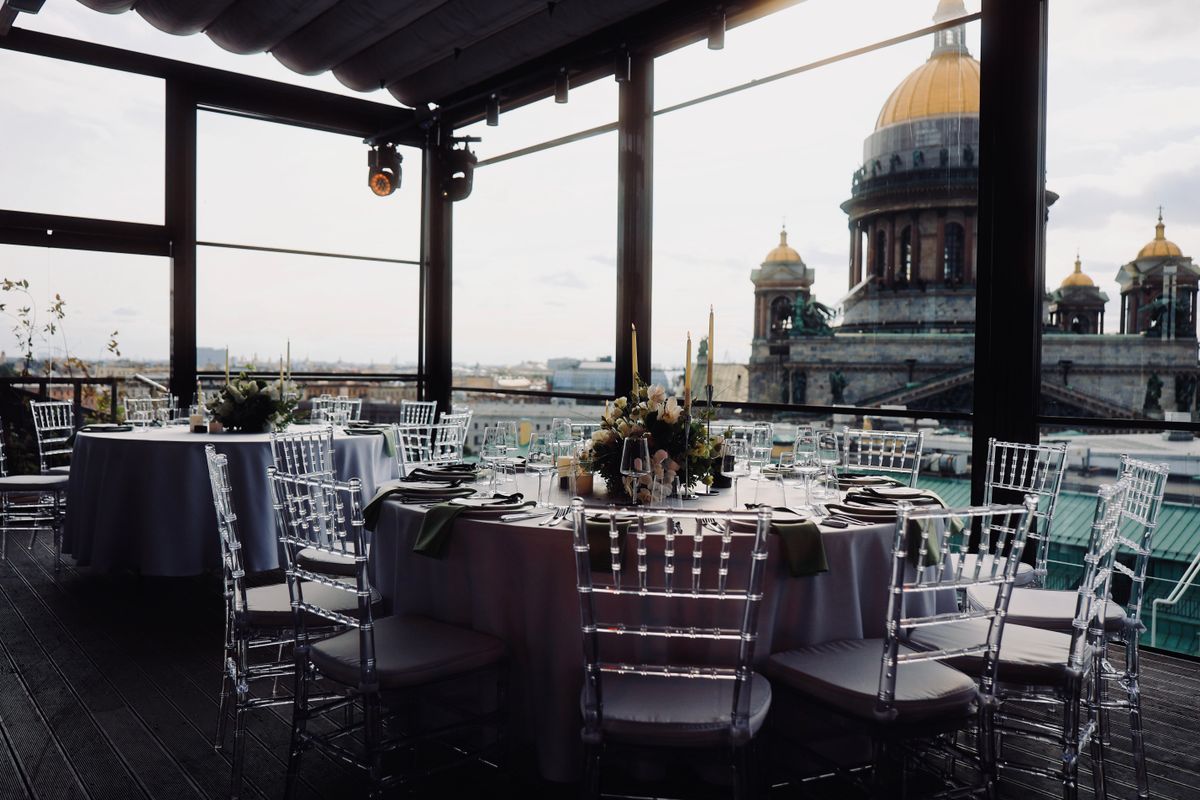 Terrazza allestita con tavoli rotondi per un evento